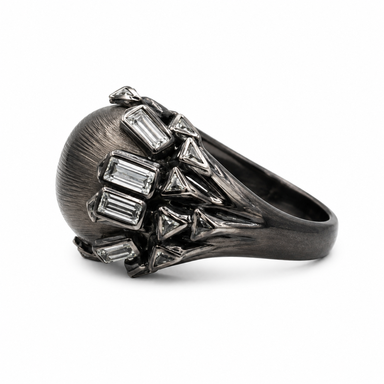 A dark oxidized silver ring featuring a large oval face embellished with baguette and triangular clear gemstones, shown on a plain white background.