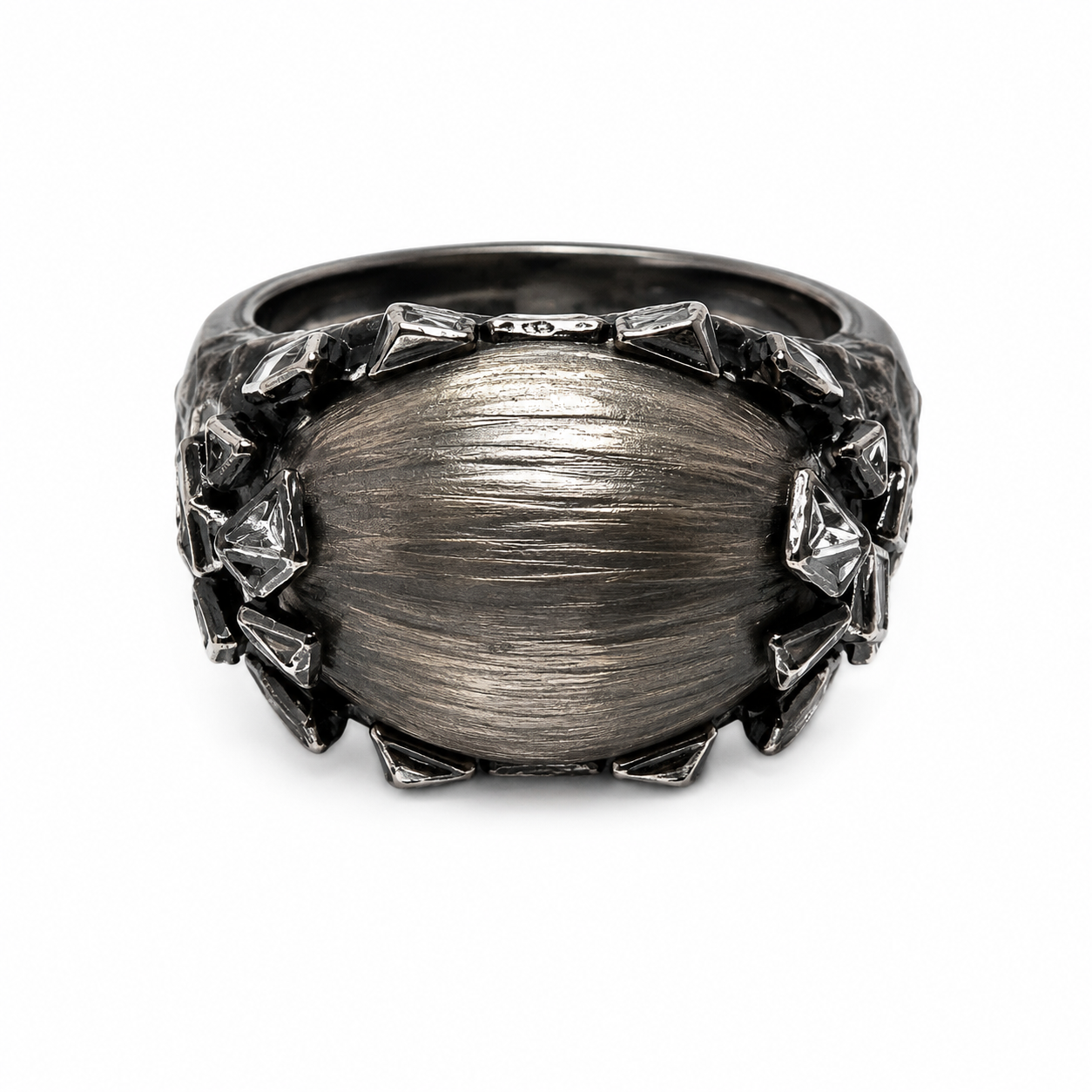 A dark gunmetal gray ring with a large, oval, brushed-metal center and textured, faceted spikes around the outer edge, shown on a plain white background.