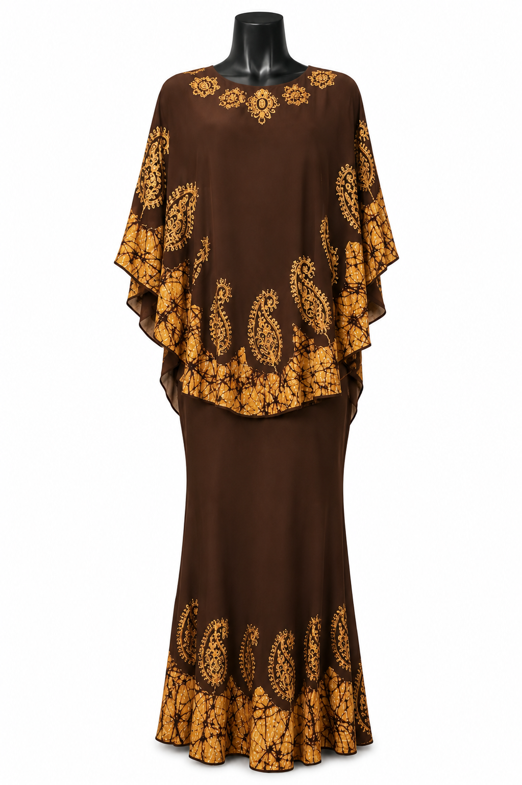 A brown two-piece dress set displayed on a black mannequin against a white background. The set features a long brown skirt and a matching long-sleeved top with a draped, cape-like overlay decorated with a golden-yellow paisley and floral pattern.