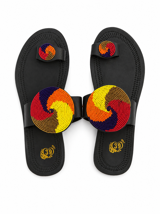 A pair of black thong sandals with large circular beaded foot straps in yellow, red, orange, and navy, and matching beaded toe loops. The soles feature a gold '39' logo.