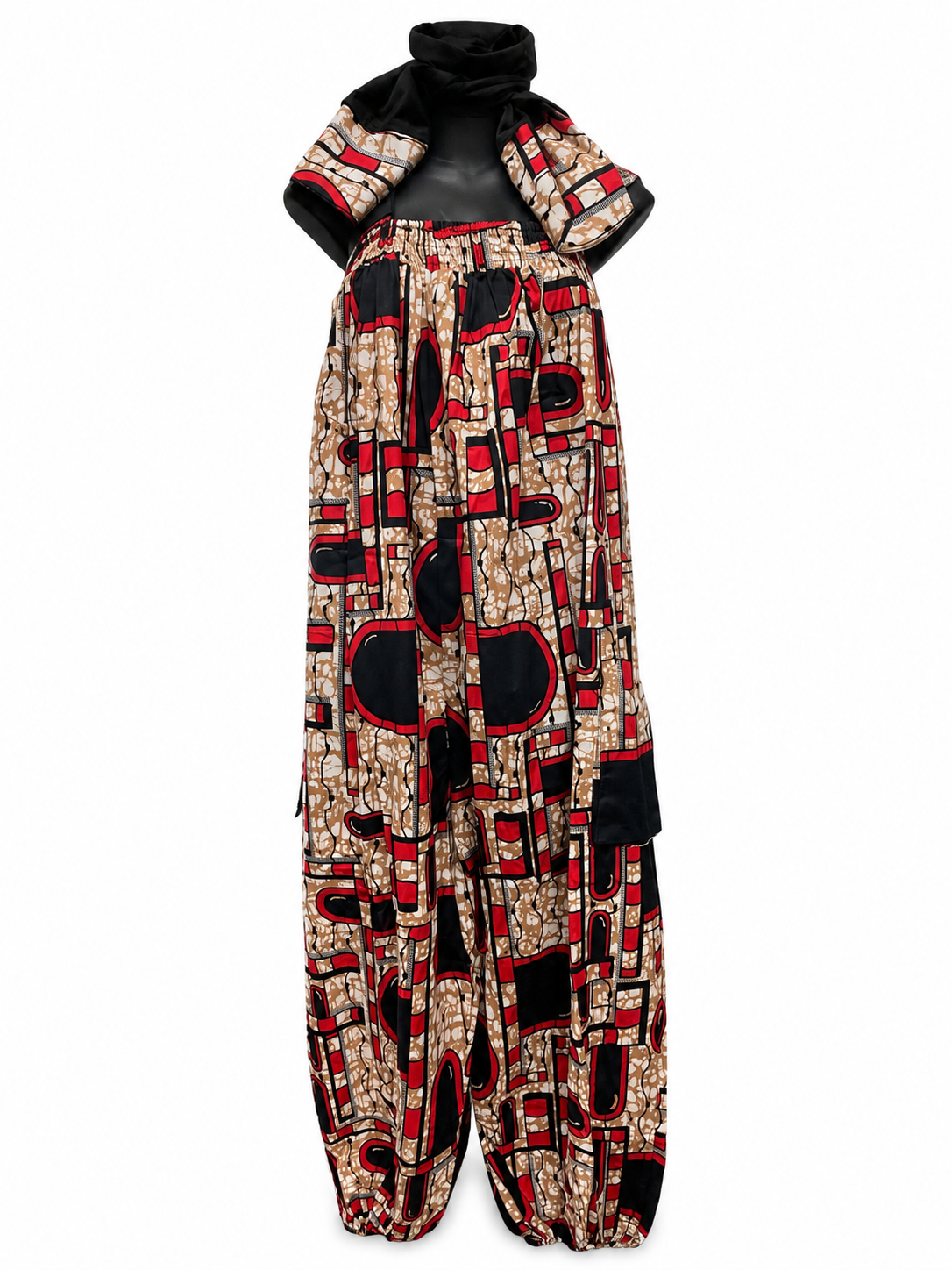 A sleeveless, wide-leg jumpsuit with an abstract geometric pattern in beige, black, and red, displayed on a black mannequin against a white background.