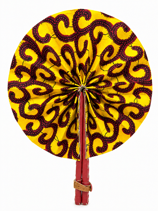A round hand fan with a bright yellow fabric decorated with a dark red and black wavy pattern, featuring a red handle and a small brown leather strap at the bottom.