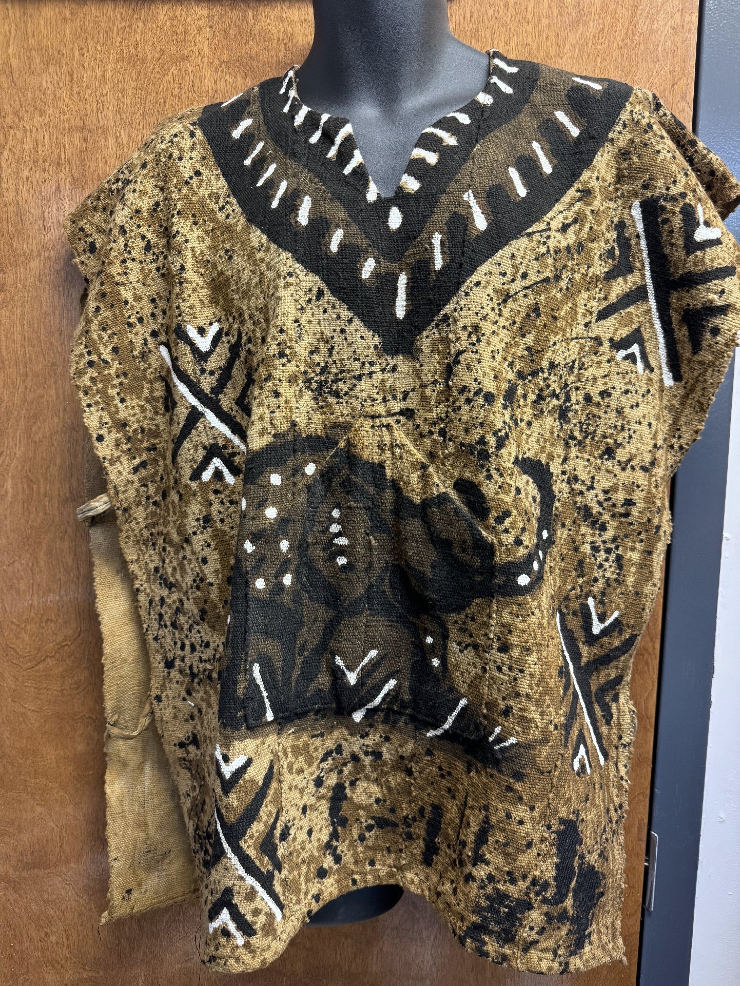 A traditional African mud cloth top featuring a prominent elephant design in black and white against a beige background.